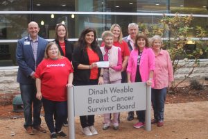 Dinah Weable (center, right) and other members of the Dinah Weable Breast Cancer Surivors Foundation joined team members of Raytheon Technologies during a check presentation Friday. (Chris Roark/staff photo)