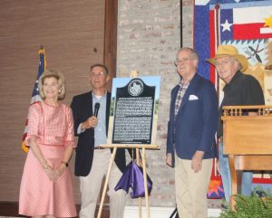 From left, Nancy Paup, Pecan Springs Ranch property owner; David Sacha, chairman of the Ellis County Historical Commission; Ted Paup, Pecan Springs Ranch property owner; and David Gravelle, member of the Texas Historical Commission, stand next to a picture of the Texas State Historical Marker located at Pecan Springs Ranch. (Chris Roark/staff photo)